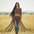 Woman wearing a multi-purpose macrame skirt from the brand altysan, with brown fringes in a field