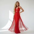 Woman wearing a red evening gown with fringe details on a white background