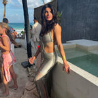 Woman in a stylish outfit standing by a pool with a beach, produced by Altysan