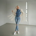 Woman wearing handmade macramé sleeve denim jacket with white fringe details and custom boho design