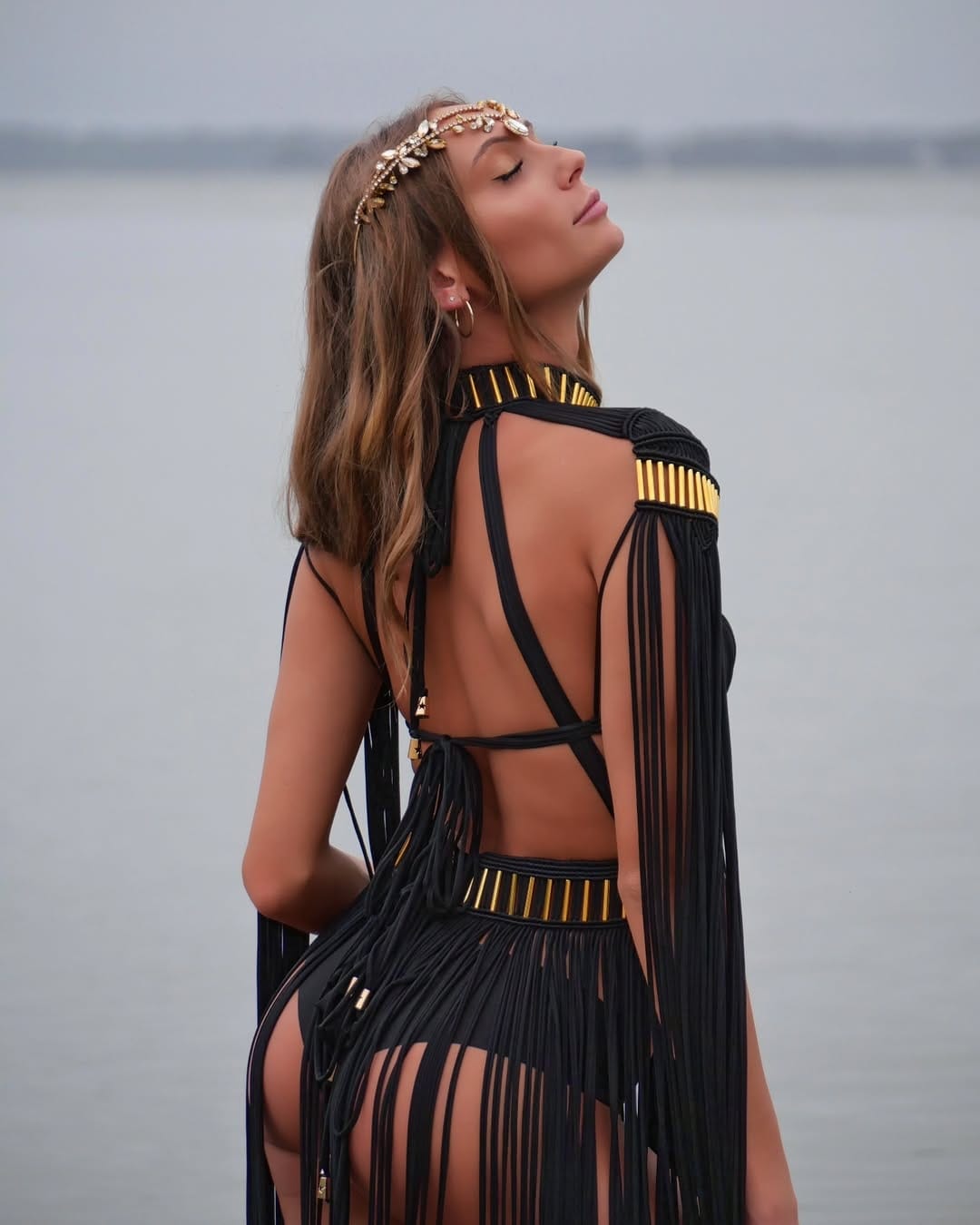 Back view of black macramé halter gown showing open-back construction and fringe