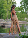 Handwoven macramé fringe maxi skirt in natural tan, worn by model in outdoor nature setting — boho wrap skirt with long fringe hem, Solaris Wrap by ALTYSAN